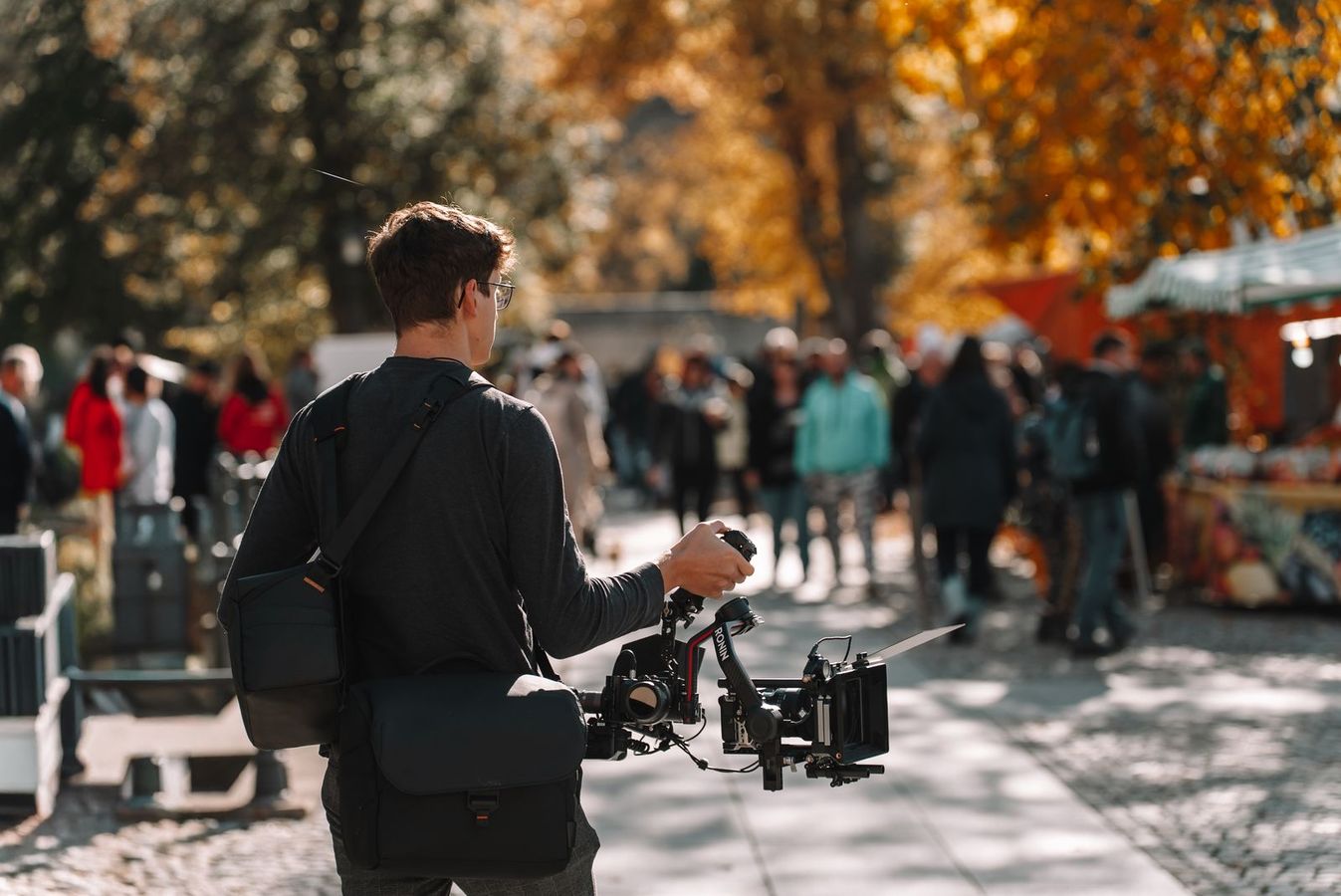Hannes filmt mit Gimbal auf einem Herbstmarkt